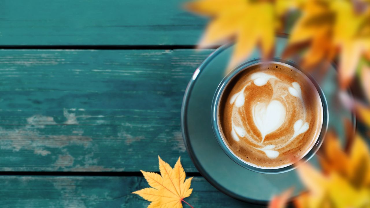 fall-themed table with latte and maple leaves