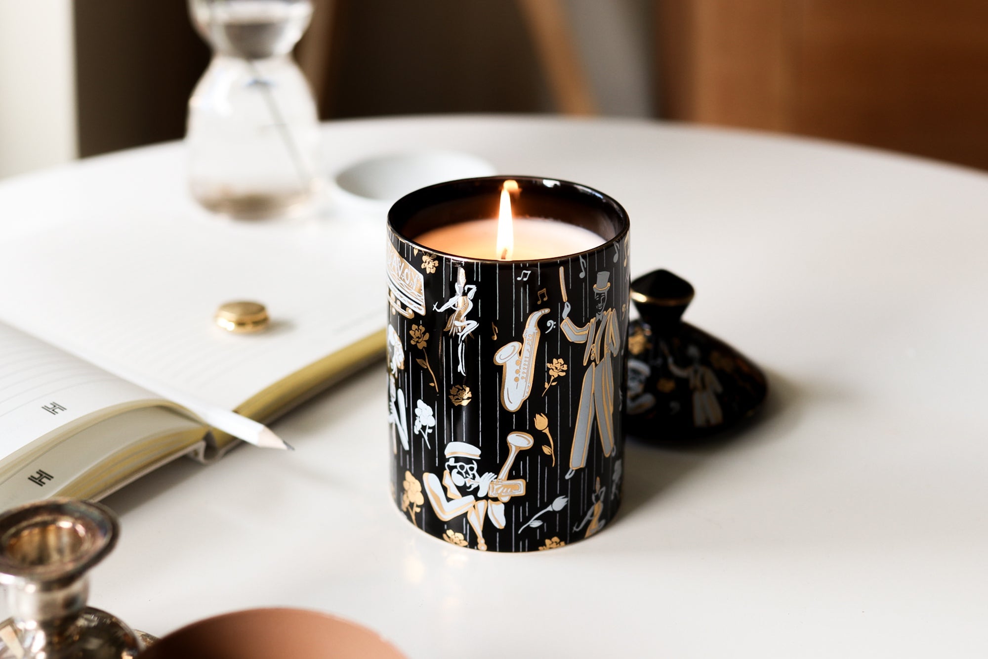 This is a lifestyle image of our Duke ceramic candle featuting illustrations of Dizzy Gillespe, Cab Calloway, and other symbols of jazz.