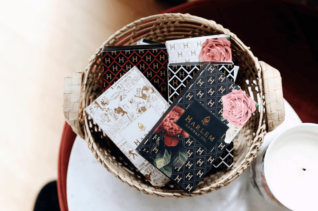 The lifestyle image shows a group of the Harlem Candle Co match boxes displayed in a decorative fashion.